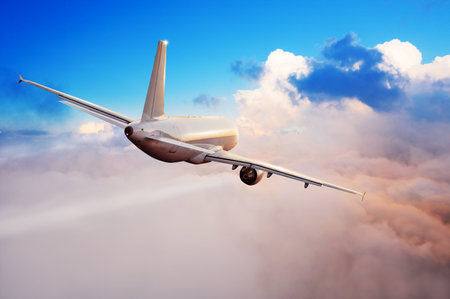 Passengers commercial airplane flying above clouds in sunset light. Concept of fast travel, holidays...