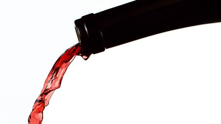 Detail of bottle with red wine pouring.の写真素材
