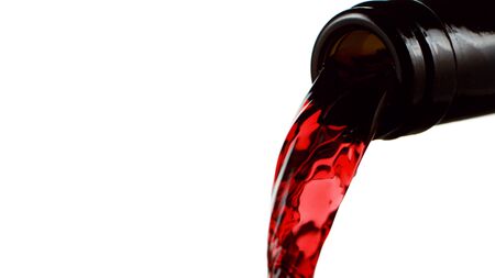 Detail of bottle with red wine pouring. Isolated on white backgroundの写真素材