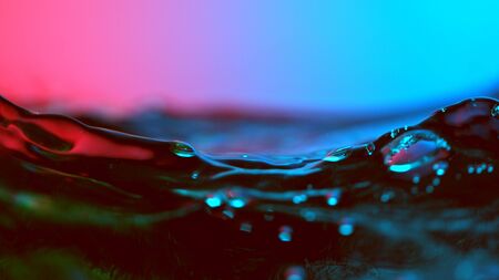 Detail of water waves highlighted by neon lights. Abstract water backgroundの写真素材