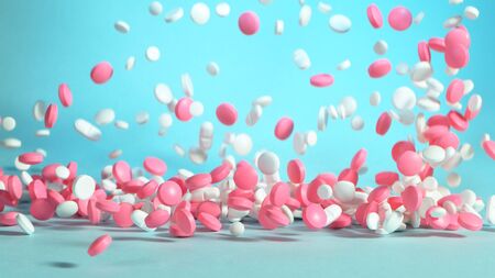 Freeze motion of flying coloured pills on white background. Health and medical conceptの写真素材