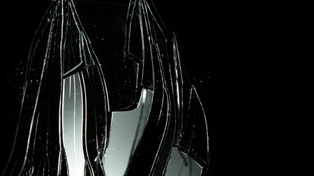 Detail of shattered glass on black background. Texture of broken glass.