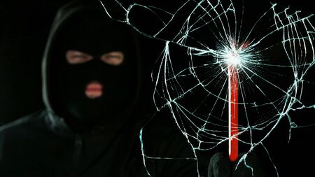 Detail of shattered glass, burglar on background. Concept of violence, burglary, broken window and insurance.の写真素材