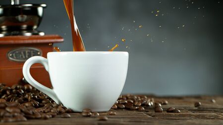 pouring coffee surrounded by coffee beans and mill. Closeup of vintage still lifeの写真素材