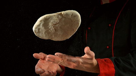 Freeze motion of cooker processing yeast pizza dough. Food preparation concept, ingredients around