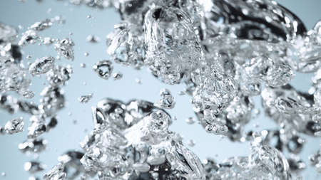 Closeup of water waves isolated on blue background, studio macro shot.の写真素材