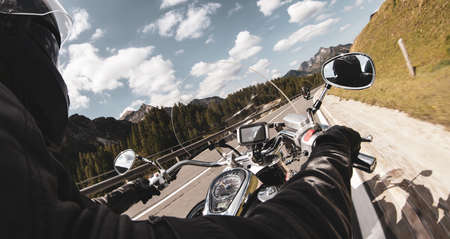 Driver riding motorcycle on an asphalt road in mountain, detail of steering bar.の写真素材