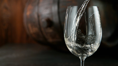 Glass of whisky with splashing liquid and ice rocks inside.. Studio shot, isolated on black backgroundの写真素材