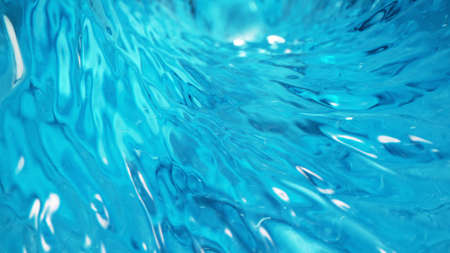 Rippling water surface in neon blue-pink colors with rain drops.の写真素材