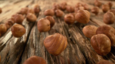 Rolling whole hazelnuts placed on wooden planks, freeze motion.の写真素材