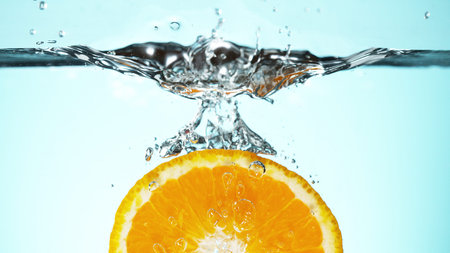Fresh lime dropped into water with splash and ice cubes. Studio shot with clear background.