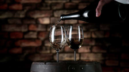 Freeze motion of white wine pouring into glass, old cellar interior.の写真素材