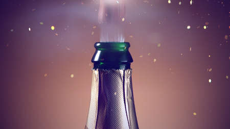 Champagne bottle beying opened. Concept of celebration New Year, birthday or success. Studio shot, freeze motion, bright golden background.の写真素材