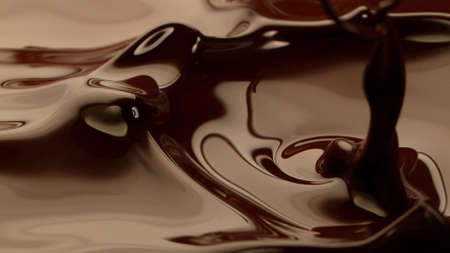Macro photo of premium dark chocolate splashing. Freeze motion, splashing melted chocolate background.の写真素材