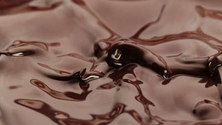 Macro photo of premium dark chocolate splashing. Freeze motion, splashing melted chocolate background.の写真素材