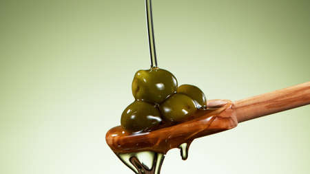 Detail of whole green olives in oil, concept of pressed olive oil.の写真素材