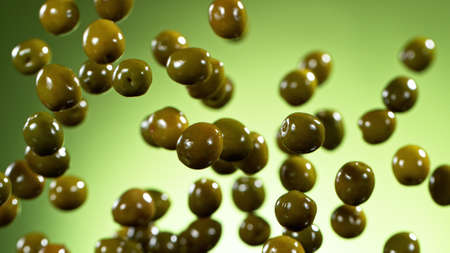 Freeze motion of flying green olives, isolated on green background.の写真素材