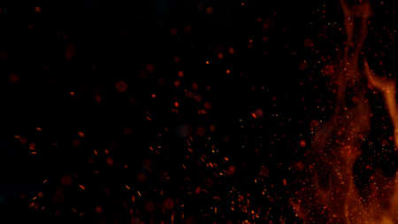 Fire sparks flying like particles on black background. Abstract background.の写真素材
