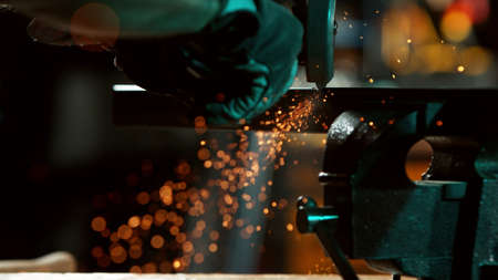 Detail of industrial worker cutting steel pipe with flex circular saw. Macro shot in workshop area.の写真素材