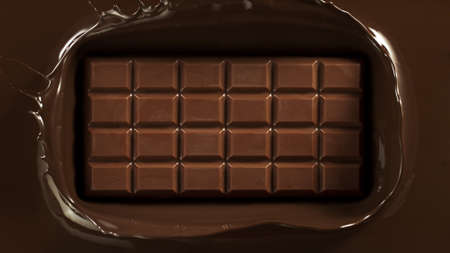 Close-up of pouring stream of melted chocolate, creating curly shapes.の写真素材