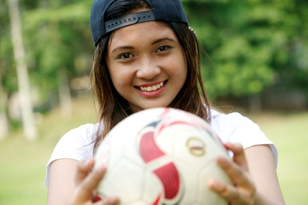 asian girl hold ball and smileの写真素材