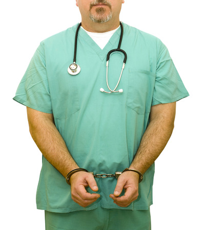 Medical Fraud - A healthcare professional in handcuffs. Good for medical or insurance fraud concepts.の写真素材