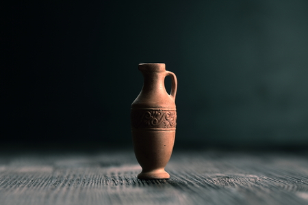 Small clay jug on a wooden tableの写真素材