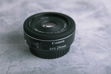 MOSCOW, RUSSIA, APRIL 21, 2017. Very popular Canon EF-S 24mm f/2.8 STM lens on a gray cement backgroundのeditorial素材