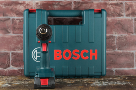 MOSCOW, RUSSIA, AUGUST 18, 2018. 18V Lithium-Ion Cordless Drill/Drivers Bosch GSR 1800-LI on a wooden table against a brick wall.のeditorial素材