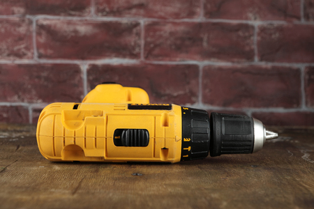 MOSCOW, RUSSIA, AUGUST 21, 2018. 12V Cordless Drill/Drivers DeWalt DW912 on a wooden table against a brick wall.のeditorial素材