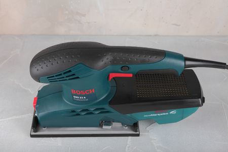 MOSCOW, RUSSIA, AUGUST 30, 2018. Grinder Bosch Professional GSS 23 A against the background of a plastered wall.のeditorial素材