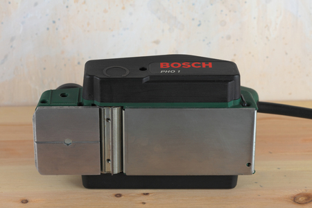 MOSCOW, RUSSIA, NOVEMBER 29, 2018. Electric planer Bosch PHO 1 on wooden table and against the background of a plastered wall.のeditorial素材