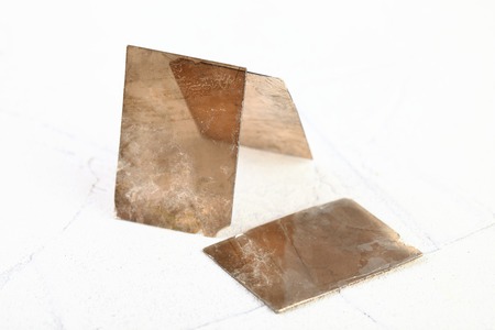 Natural mineral from geological collection - rough muscovite mica, common mica on white cement background from Poldnevoe, Ural, Russia.の写真素材