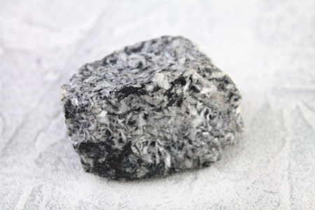 Natural rock - piece magnesite mineral stone from Satka, Ural, Russia on white cement background.