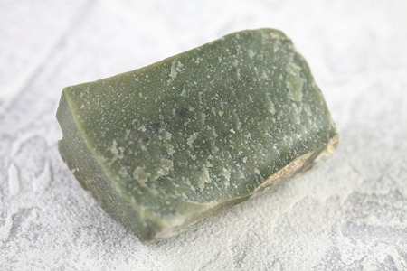 Natural mineral Ophicalcite is a calcified calcite from Satka, Ural, Russia on white cement background.の写真素材