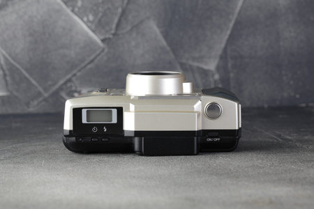 The old Japan 35 mm compact film camera Olympus Wiev Zoom 120 with 38-120 mm glass lens, released 2001 on gray cement background.のeditorial素材