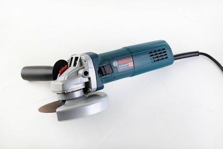 Angle Grinder Bosch GWS 9-125 s on white cement background. Bosch tools.のeditorial素材