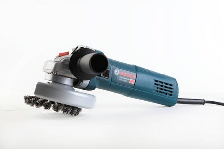 Angle Grinder Bosch GWS 9-125 s on white cement background. Bosch tools.のeditorial素材
