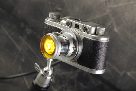 A vintage lamp made by me from an old rangefinger film camera Zorki relased on 1955 on a gray cement...