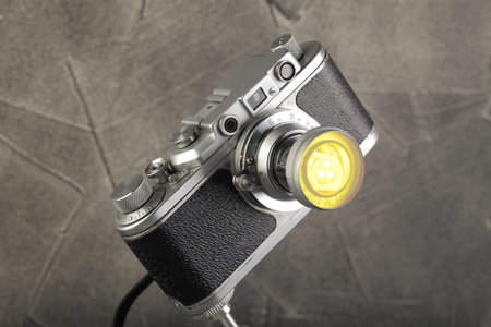 A vintage lamp made by me from an old rangefinger film camera Zorki relased on 1955 on a gray cement...