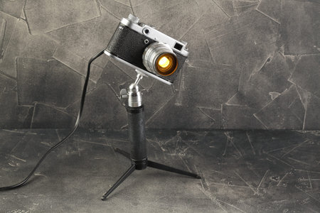 A vintage lamp made by me from an old film camera FED-2 on a gray cement background.