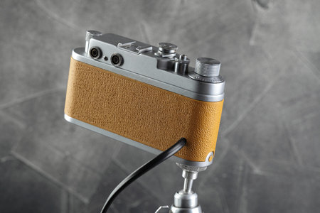 A vintage lamp made by me from an old film camera on a gray cement background.