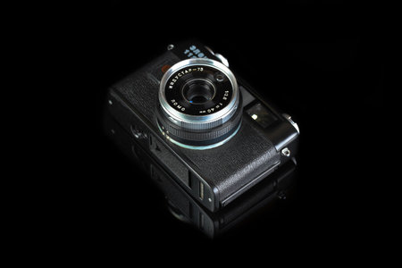 MOSCOW, RUSSIA, APRIL 18, 2021. The old Soviet rangefinder automatic film camera Electra 122, released 1981 on black glass background with reflection.のeditorial素材