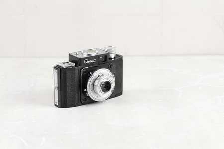The old Soviet 35mm. scaling film camera Smena, released 1955 on white cement background.のeditorial素材