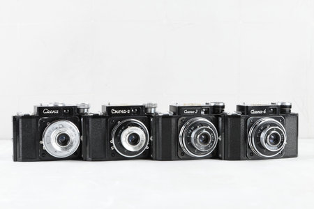 The old Soviet 35mm. scaling film cameras Smena, Smena 2, Smena 3, Smena 4, released from 1955 to 1960 on white cement background.のeditorial素材