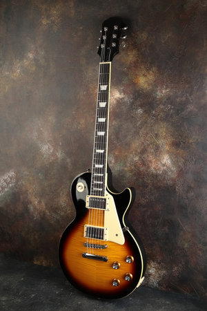 Old electric guitar against the background of a red concrete wall.の写真素材