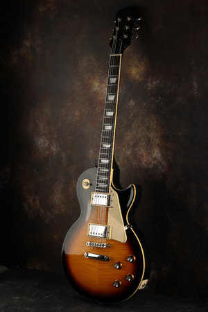 Old electric guitar against the background of a red concrete wall.の写真素材