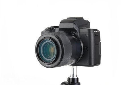 Black and Modern digital mirrorless Camera with lens on white background.