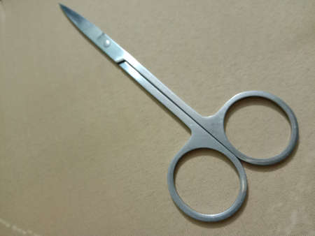 silver colored scissors closeup on golden backgroundの写真素材