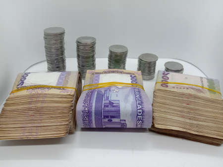 bangladeshi bank note and coin on white backgroundの写真素材